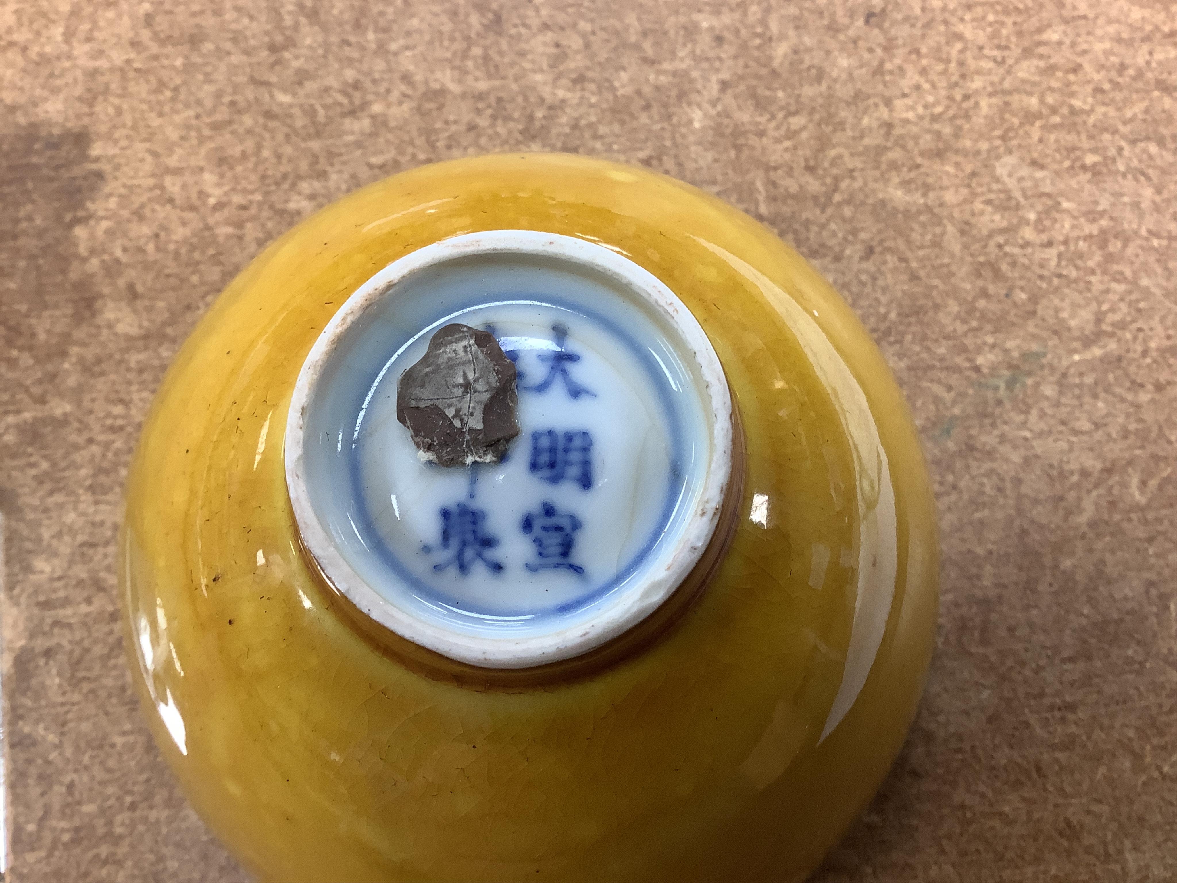 A Chinese yellow glazed teabowl on hardwood stand, 9cm diameter. Condition - fair